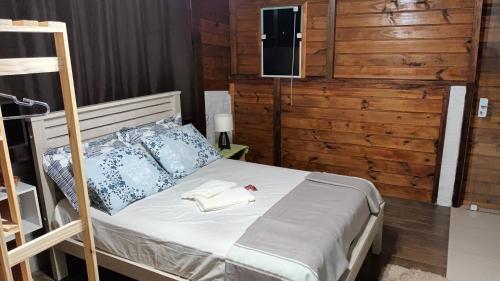 布卢梅瑙Suíte privativa 11km vila germânica的卧室配有一张床铺,墙上配有电视