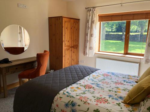 肯梅尔Lissyclearig Lodge的一间卧室配有一张床、一张书桌和一个窗户。