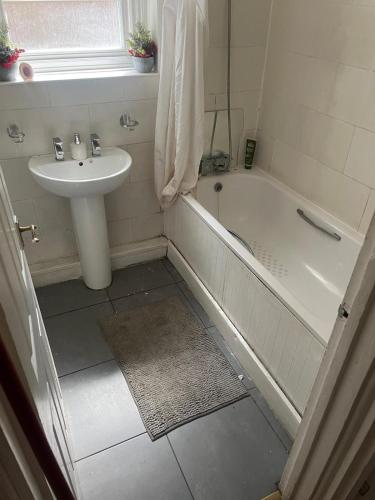 伦敦Home 2 Home的浴室配有盥洗盆、浴缸、卫生间和盥洗盆。
