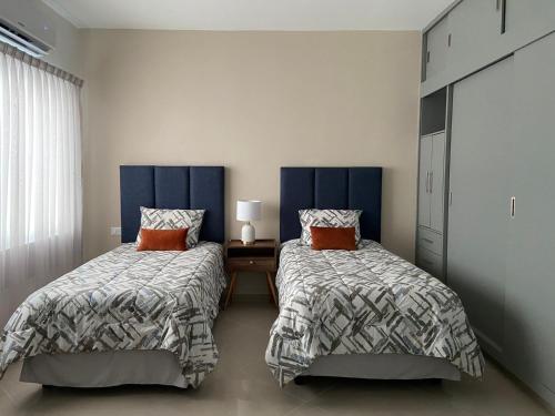 比亚埃尔莫萨Departamento colonia Carrizal的一间卧室设有两张床、一张桌子和一个窗口