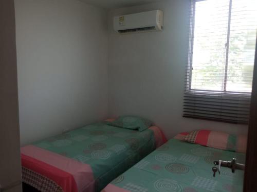 科韦尼亚斯Cómodo apartamento cerca al mar的小型客房设有两张单人床和窗户。