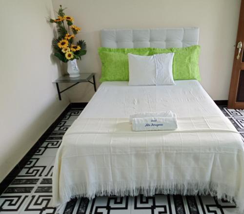 莱蒂西亚Hotel Alto Amazonas的一间卧室配有一张白色的床,上面装有盒子