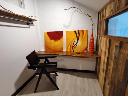 怡保7 Wooden Lodge Ipoh City的一张桌子,一张桌子,放在一个椅子和绘画的房间