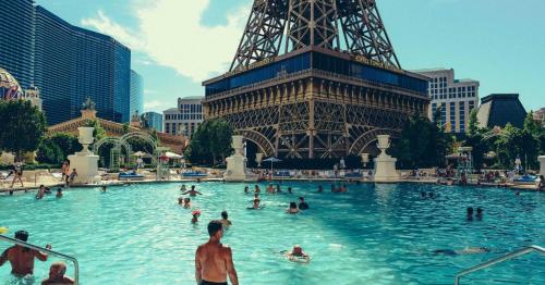 拉斯维加斯Attractive Unit by Paris Casino Heart of Strip Las Vegas的一群人,在埃菲尔铁塔前的游泳池里