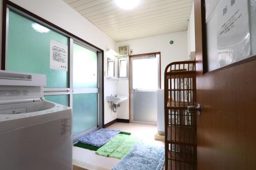 米子市水香园日式旅馆 的浴室设有门、水槽和洗衣机。