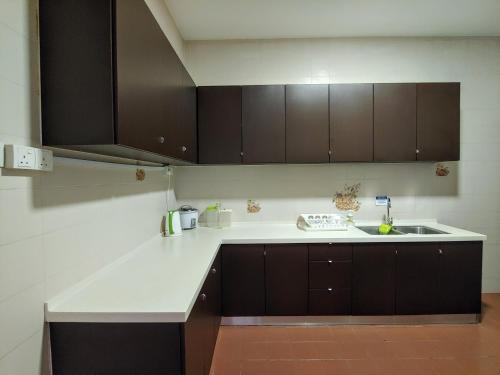 乔治市新关仔角城公寓的厨房配有棕色橱柜和水槽