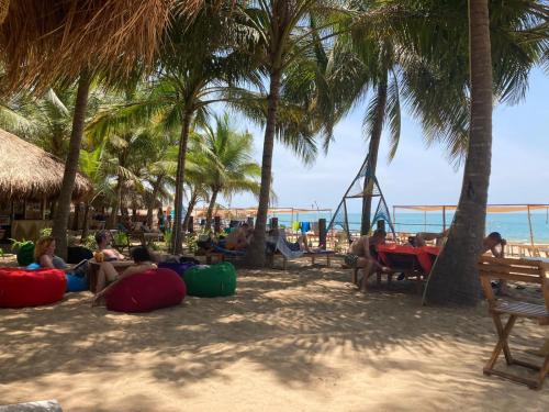 阿鲁甘湾Atteriya CHILL的一群人坐在棕榈树海滩上