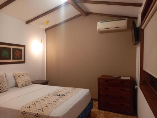佩德纳莱斯Hosteria SR的一间卧室配有带梳妆台的床铺和空调。