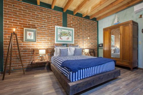 拉巴斯Aquamarina的一间卧室设有一张床和砖墙
