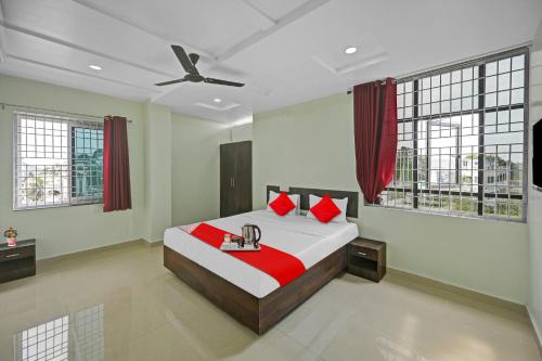 KurmannapalemOYO VRK Residency的一间卧室配有一张带红色枕头的大床