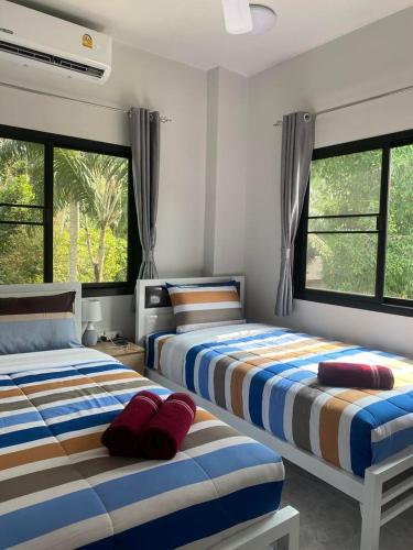 卡农Okat pool villa khanom的带2扇窗户的客房内的2张床