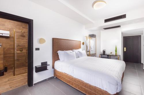 纳哈里亚מלון בוטיק H34的一间卧室设有一张大床和淋浴