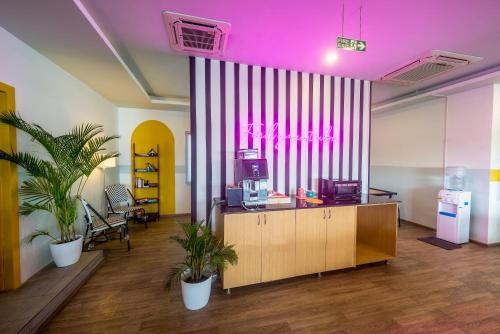 班加罗尔Olive Indiranagar - By Embassy Group的一间设有粉红色天花板和两座盆栽植物的办公室