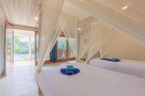 Airtembago塔拉萨雷姆贝潜水度假村的一间卧室设有两张床和窗户。
