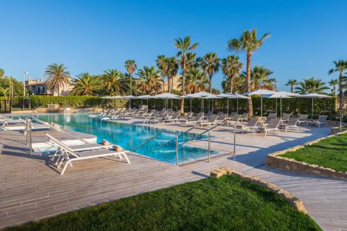 科斯塔巴伦娜厄尔巴鲸鱼海岸沙滩与海水浴疗酒店的一个带躺椅和遮阳伞的游泳池