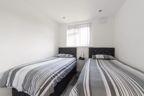 Saint Martin2 bedroom luxury beach apartment Millendreath的白色墙壁客房的两张床