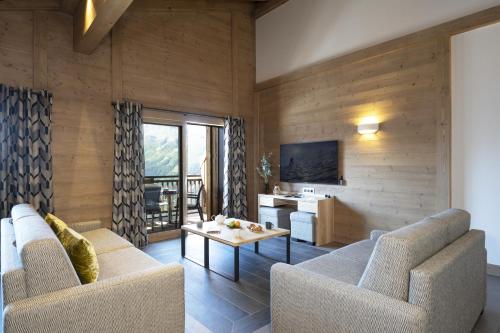 拉赫兹耶尔Hôtel Alpen Lodge的客厅配有两张沙发和一张桌子