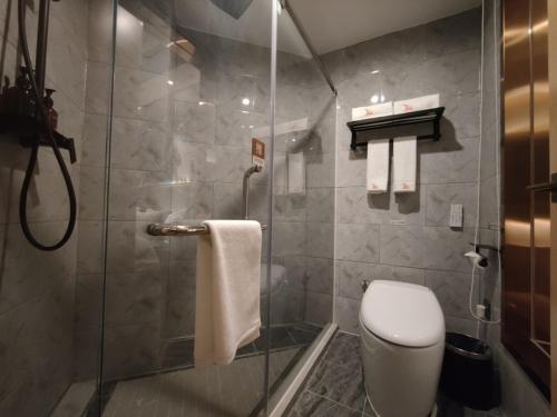 深圳格林东方深圳福田区市民中心景田地铁站酒店的带淋浴、卫生间和毛巾的浴室