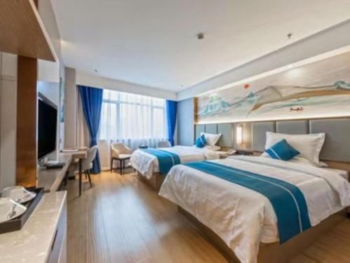 Yinzhan格林东方都匀瓮安县锦美时代汽车站酒店的酒店客房设有两张床和电视。