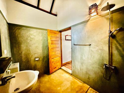阿鲁甘湾Riva del Sole Guest House的一间带水槽和淋浴的浴室以及一扇门