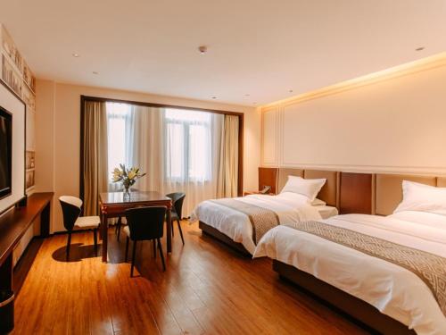 亳州格美安徽省亳州市亳州学院酒店的酒店客房配有两张床和一张书桌