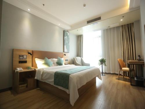 安庆格林豪泰安庆市迎宾东路高铁站客运中心酒店的一间卧室配有一张床、一张书桌和一个窗户。