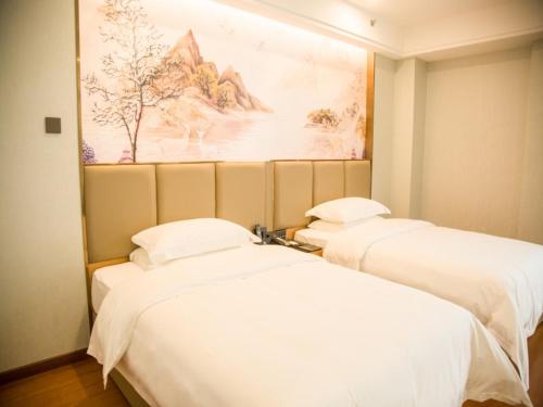 浚县格林东方鹤壁市浚县客运站酒店的墙上画画的房间里设有两张床