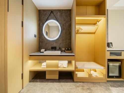 Jiangning格林东方南京江宁大学城酒店的一间带水槽和镜子的浴室