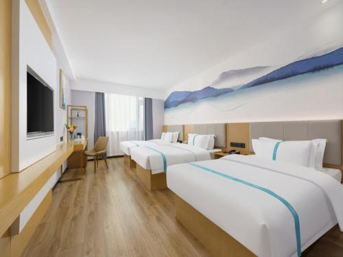 大连格菲辽宁省大连市甘井子区周水子机场酒店的酒店客房设有两张床和一台平面电视。