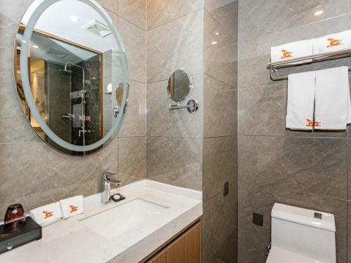 蚌埠格林东方蚌埠淮上区政府国购广场丽景天成酒店的一间带水槽、镜子和卫生间的浴室