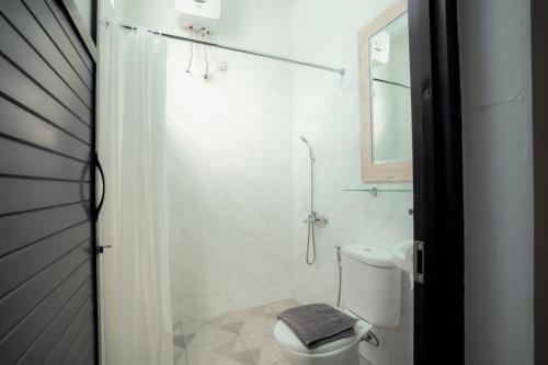 纳闽巴霍El Ora Hotel & Eatery Labuan Bajo的白色的浴室设有卫生间和淋浴。