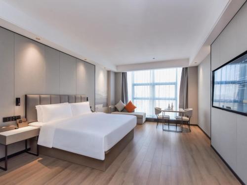 重庆格林东方重庆江北国际机场鹿山地铁站酒店的一间带白色大床的卧室和一间客厅