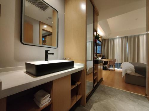 乌鲁木齐格林东方新疆乌鲁木齐人民路酒店的一间带水槽和镜子的浴室以及一张床