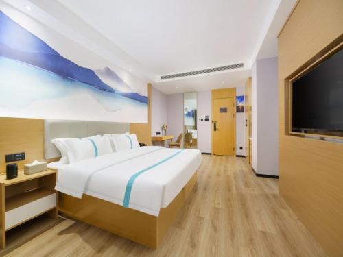 南宁格丽酒店南宁火车东站店的一间卧室配有一张大床和一台平面电视