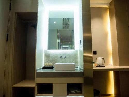 宜春格菲宜春市袁州区政府高铁站酒店的一间带水槽和镜子的浴室