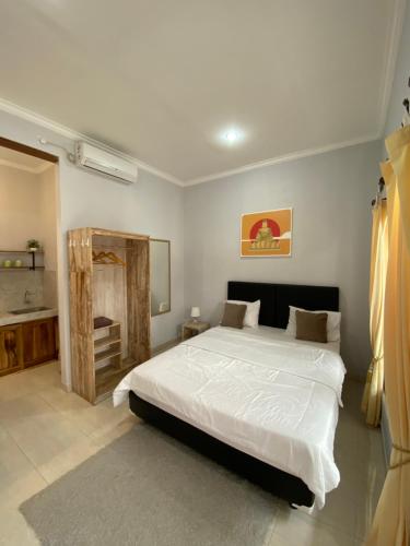Ketewel拉格里亚旅馆的卧室配有一张白色大床