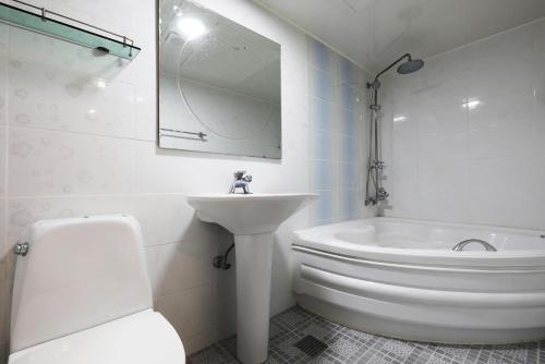 水原市Suwon Hotel Praha的白色的浴室设有水槽、卫生间和浴缸。
