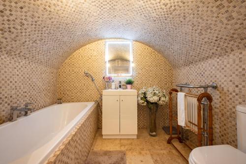 伦敦Niru Experience Hidden Gem in Chelsea的带浴缸和卫生间的浴室。