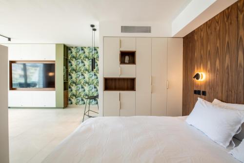 埃拉特Beach Side- Ceasar Luxury Amazing Pool Eilat的卧室配有白色的床和木制床头板