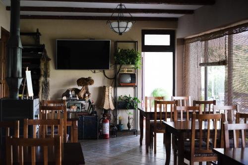 BurreliHotel Vila Bruci的一间带桌椅和电视的用餐室