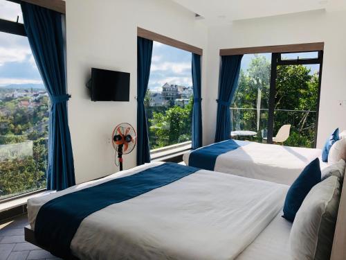 洛伊城Nắng's Villa & Coffee的带大窗户的客房内的两张床