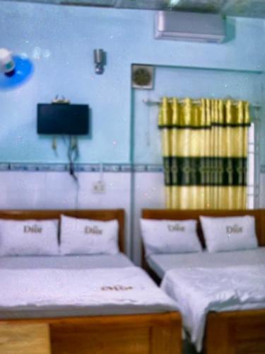 迪石Vân tiến的一间设有两张床和一台电视的房间