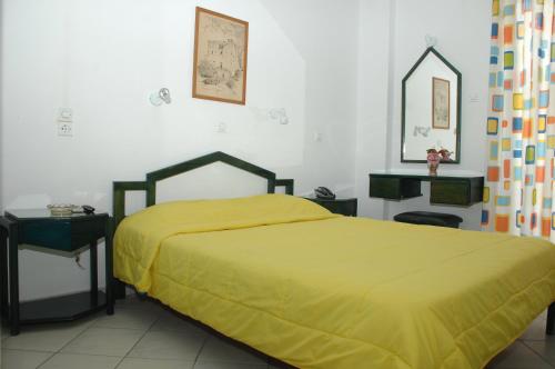 托隆Koronis Hotel的一间卧室配有一张黄色床罩的床