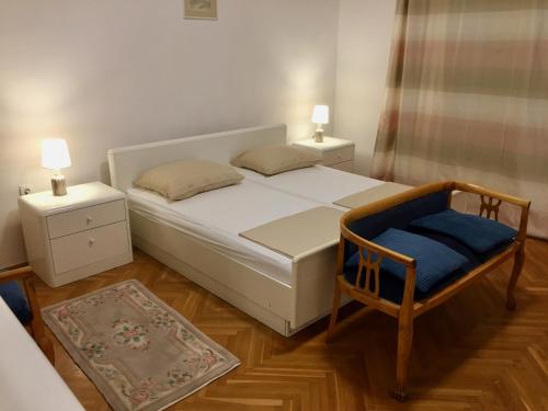 萨拉热窝Guest House Gaj Sarajevo的一间卧室配有一张床、一把椅子和两盏灯。