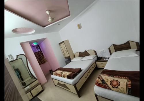孟买Hotel Broadway Colaba的一间卧室配有两张床和镜子