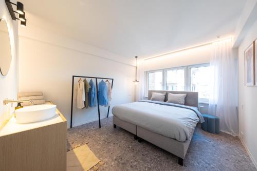 奥斯坦德Luxury Design Apartment with free private parking的一间卧室配有床、水槽和镜子