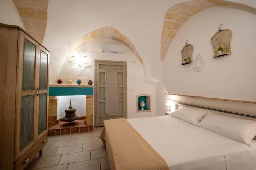 梅萨涅Tenuta Donna Caterina by BarbarHouse的一间带白色床的卧室,位于带拱门的房间
