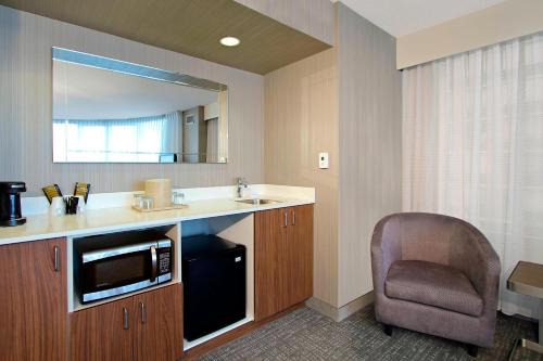 奥克兰奥克兰中心万怡酒店的浴室设有水槽、椅子和镜子