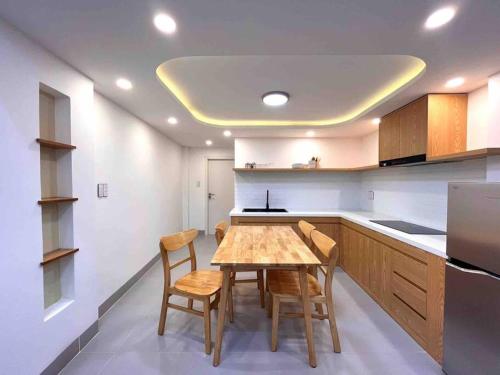 岘港Central, Minimalist and Cozy - Gau's House的厨房配有木桌和一些椅子