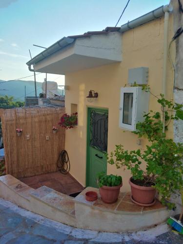 圣马太奥斯ilianas place的一座小房子,有绿门和盆栽植物